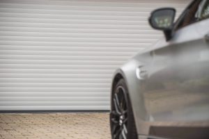 white roller shutter garage door with vehicle